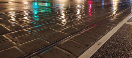 pavement wet from the rain with reflective lights in the evening.の写真素材