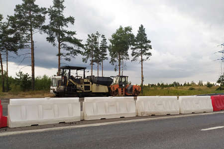road repair, road machinery on the side of an empty road.
