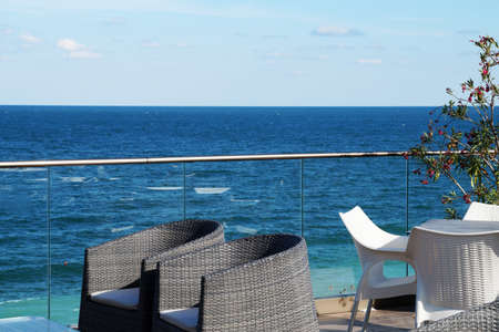 armchairs and a table for relaxing on the patio overlooking the sea.
