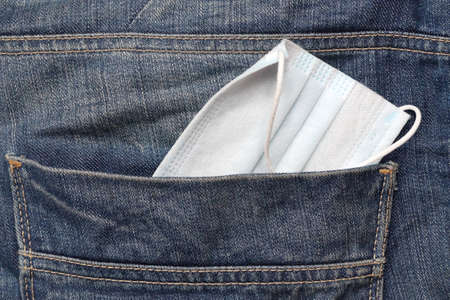 protective medical mask in jeans pocket close upの写真素材
