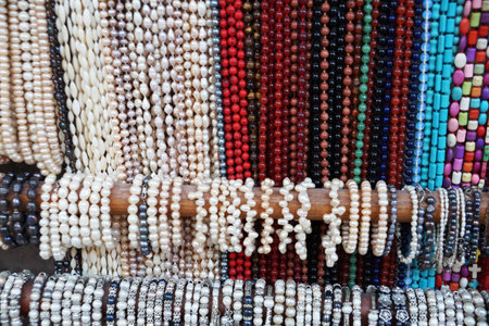 many multi-colored beads and bracelets hang on the counter.