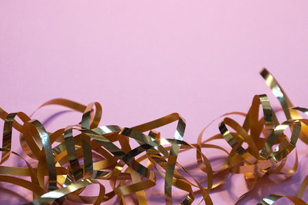 wavy gold ribbon on pink background, copy space for new year, christmas.の写真素材
