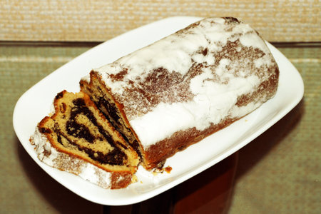 christmas sholen with poppy seeds and raisins on a white plate.