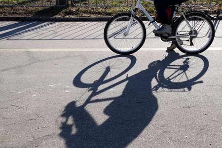 the shadow of a riding cyclist on a sunny day.