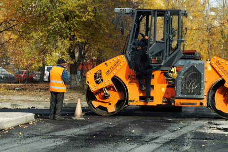 Kazan, Russia - October, 12, 2020: workers next to the asphalt paving machine