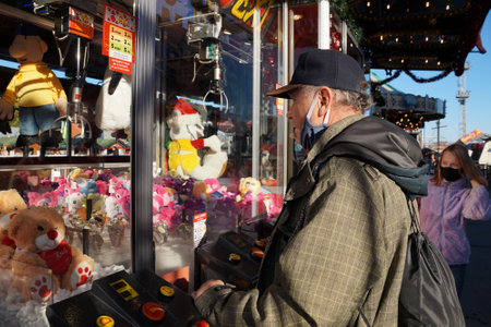 Varna, Bulgaria - November, 27, 2020: men playing on the machine with soft toys