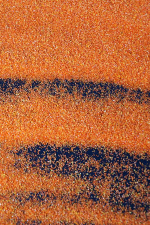 orange artificial sand on black table for background.