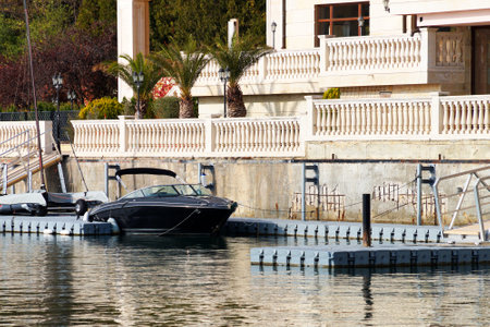 black pleasure boat moored by a beautiful villa.のeditorial素材