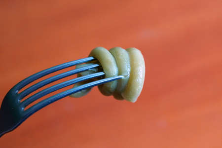 spiral pasta on a fork close-up on a wooden background copy spaceの写真素材