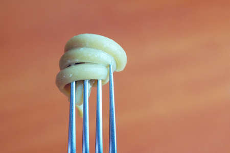 spiral pasta on a fork close-up on a wooden background copy spaceの写真素材
