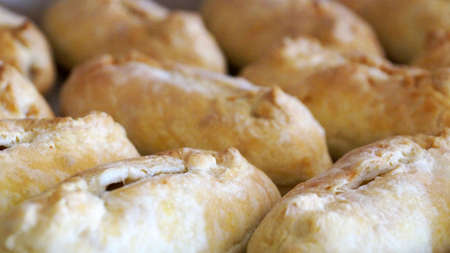 baked ruddy little pies on a baking sheet for food background close-upの写真素材