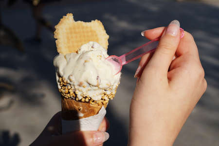 girl eating ice cream in a waffle cone hands close-up