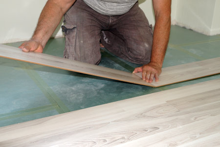 a man is installing a laminate on the floor close upの写真素材