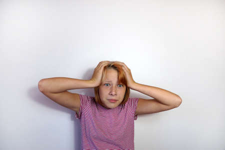 surprised teenage girl grabbed her head with her hands, copy spaceの写真素材