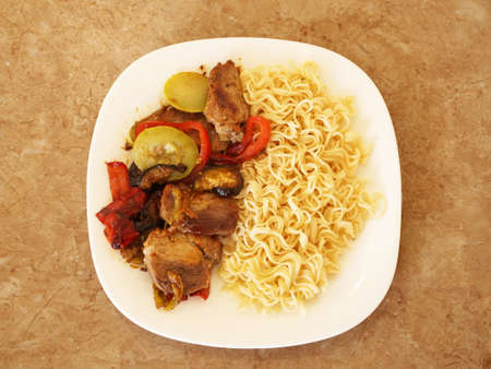 spaghetti with meat and vegetables on a white plate top viewの写真素材