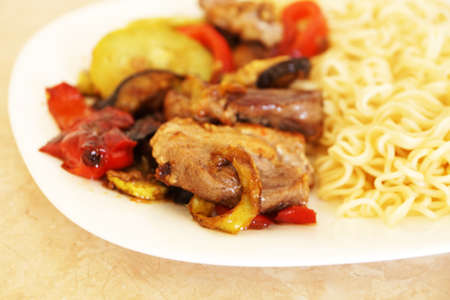 spaghetti with meat and vegetables on a white plate close-upの写真素材