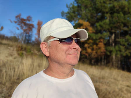 portrait of a smiling man in sunglasses and a cap in nature.の写真素材