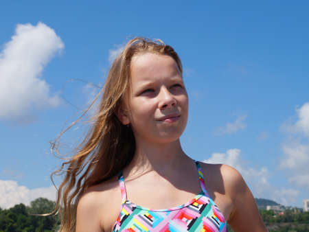 portrait of a teenage girl with long blond hair on a summer sunny day.