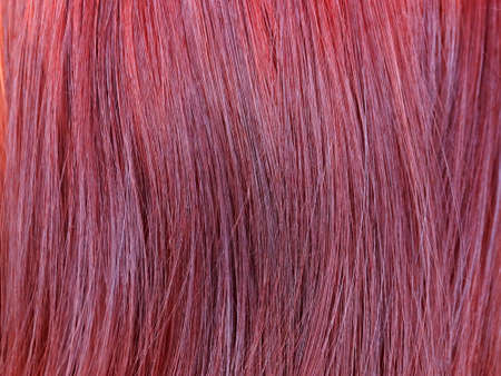 dyed red female hair closeup, texture for background.の写真素材