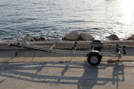car trailer for transporting boats on the sea pier in sunlightの写真素材