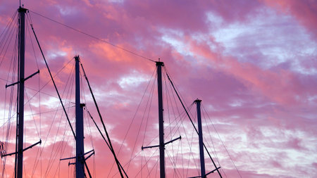 masts of a yacht without sails against the background of a sunset cloudy sky, copy spaceの写真素材