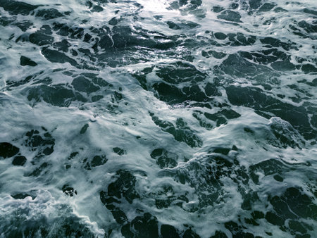 texture of turquoise sea water with white foam for water background close-upの写真素材