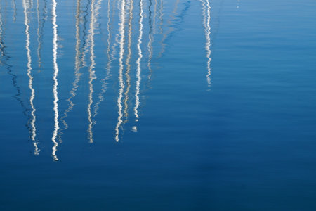 yachts match reflected in blue sea water.の写真素材