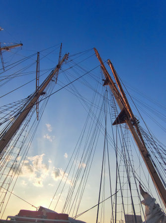 Yacht masts without sails against a clear sunny sky, view from below.の写真素材