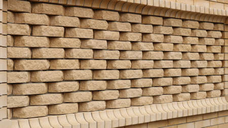 decor of the brickwork pattern of smooth and textured sand-colored bricks as a fragment of the...