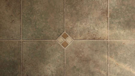 gray-brown tiled street background with abstract geometric mosaic and accent in the center of the...