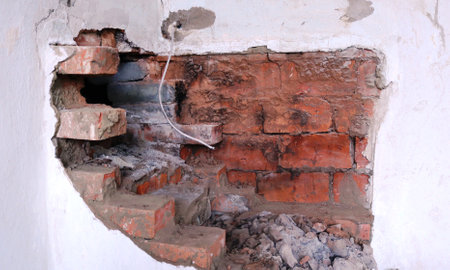 antique red brick bleached oven in the process of dismantling side view, relief of dismantled...