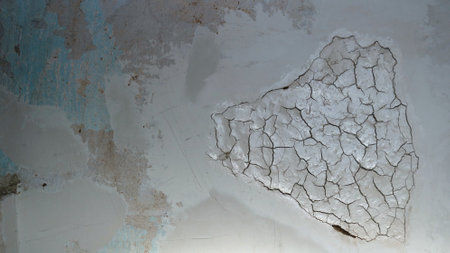 a unique textured light background of a fragment of an old wall with a convex pattern of cracks and...