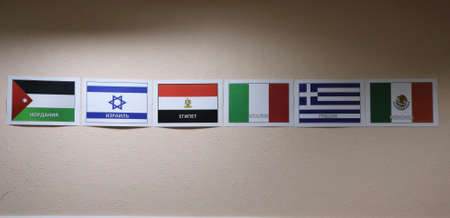 paper flags of states with the names of countries in Russian: Jordan, Israel, Egypt, Italy, Greece,...