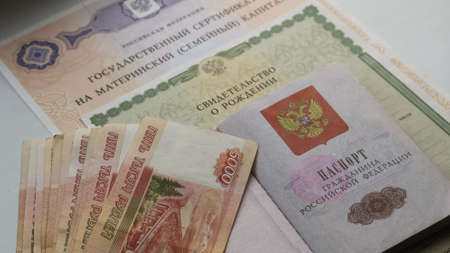 passport of a citizen of the Russian Federation in a composition with a wad of money for five thousand rubles and documents on birth and the right to maternity capitalのeditorial素材