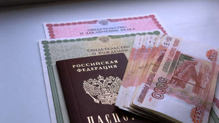 Maikop, Adygea Republic, Russia - February 6, 2021: a large amount of money in rubles lying on top of a stack of documents of a citizen of the Russian Federationのeditorial素材