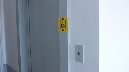 metal elevator doors in the house and a corner wall fragment with a call button and a yellow sign...