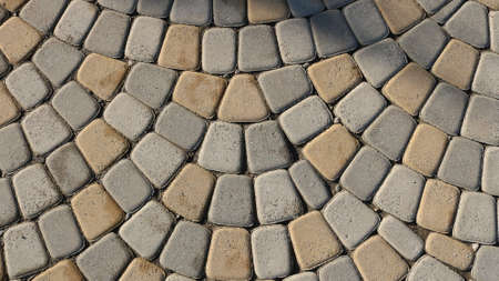 gray-beige natural processed stone in the structure of a paved pavement as a textured relief...
