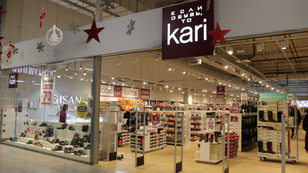 Maikop, Adygea Republic, Russia - February 15, 2021: fashionable store of shoes and accessories kari in a shopping center in Russia, goods on illuminated windows and walking visitorsのeditorial素材