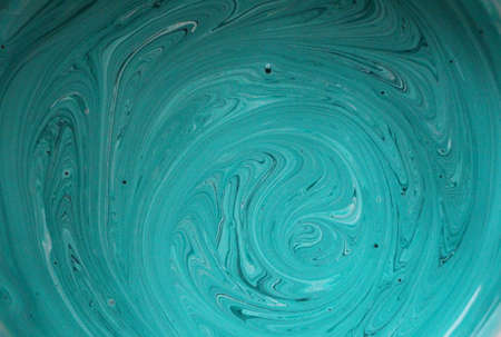 greenish-blue color of a thick paint with waves of fluid movement, a moving background of a delicate...