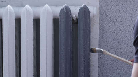 vintage heating radiator that can be painted from white to gray using a special long brush with a...