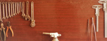 tool kit board for carpenter or locksmith in workshop with copy space in the center, various wrenches and adjustable wrenches and pliers and measuring instruments for manual laborの写真素材