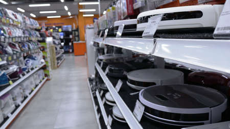 Maikop, Republic of Adygea, Russia - July, 21, 2021: blurred background of a department of household appliances in a shopping center with robotic vacuum cleaners in the foregroundのeditorial素材