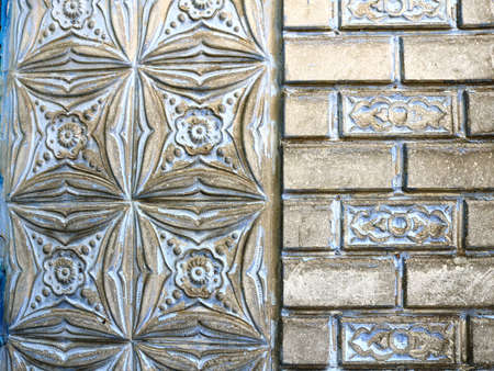 a fragment of a part of a building made of combined parts of masonry painted with silver paint, the...