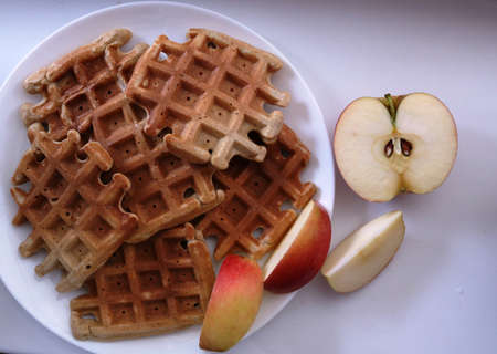homemade square waffles with red apple slices on white plate upper angle view, homemade breakfast or...
