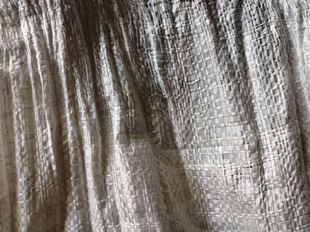 shaded crumpled canvas bag as fabric texture full frame, light tone rustic agricultural backdrop...