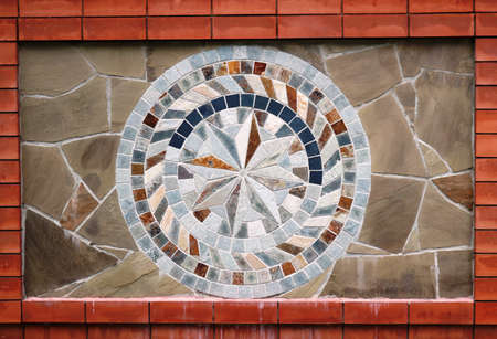 stone mosaic in the exterior decoration of the facade, natural stone tiles in the structure of a circular patterned symbol, a combination of stone in the exterior decoration of the buildingの写真素材