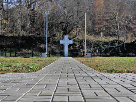 Apsheronsk, Krasnodar region, Russia - January 2, 2022: memorial cross in the memorial complex with a paved area with an empty mine space, a religious symbol made of stone at the burial siteのeditorial素材
