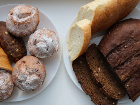 bread background with two white plates with an assortment of pastries from different types of flour,...