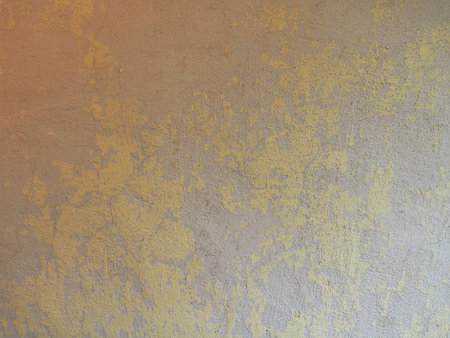 shabby empty wall as texture background, surface graphic resource with peeling plaster remnants, backdrop of empty room wall with crumbling plasterの写真素材