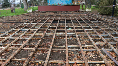 construction site with a structure of old iron beams covered with rust in the park, enclosed with tape, a site for the reconstruction of the foundation of a public facilityの写真素材